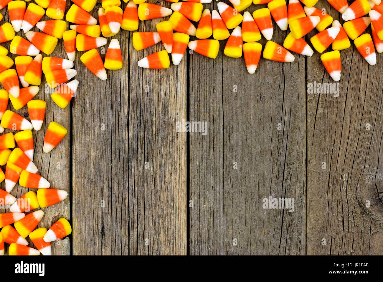 Halloween Süßigkeiten Mais oben Grenze vor einem rustikalen Holz Hintergrund Stockfoto