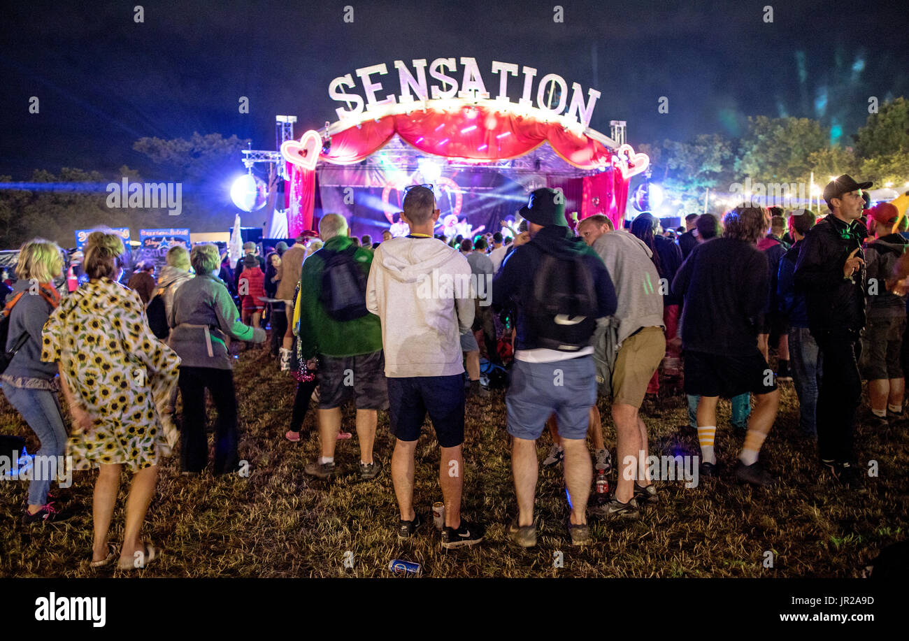 Menschen, die durch eine kleine Bühne bei Nacht Glastonbury Festival in Großbritannien Stockfoto