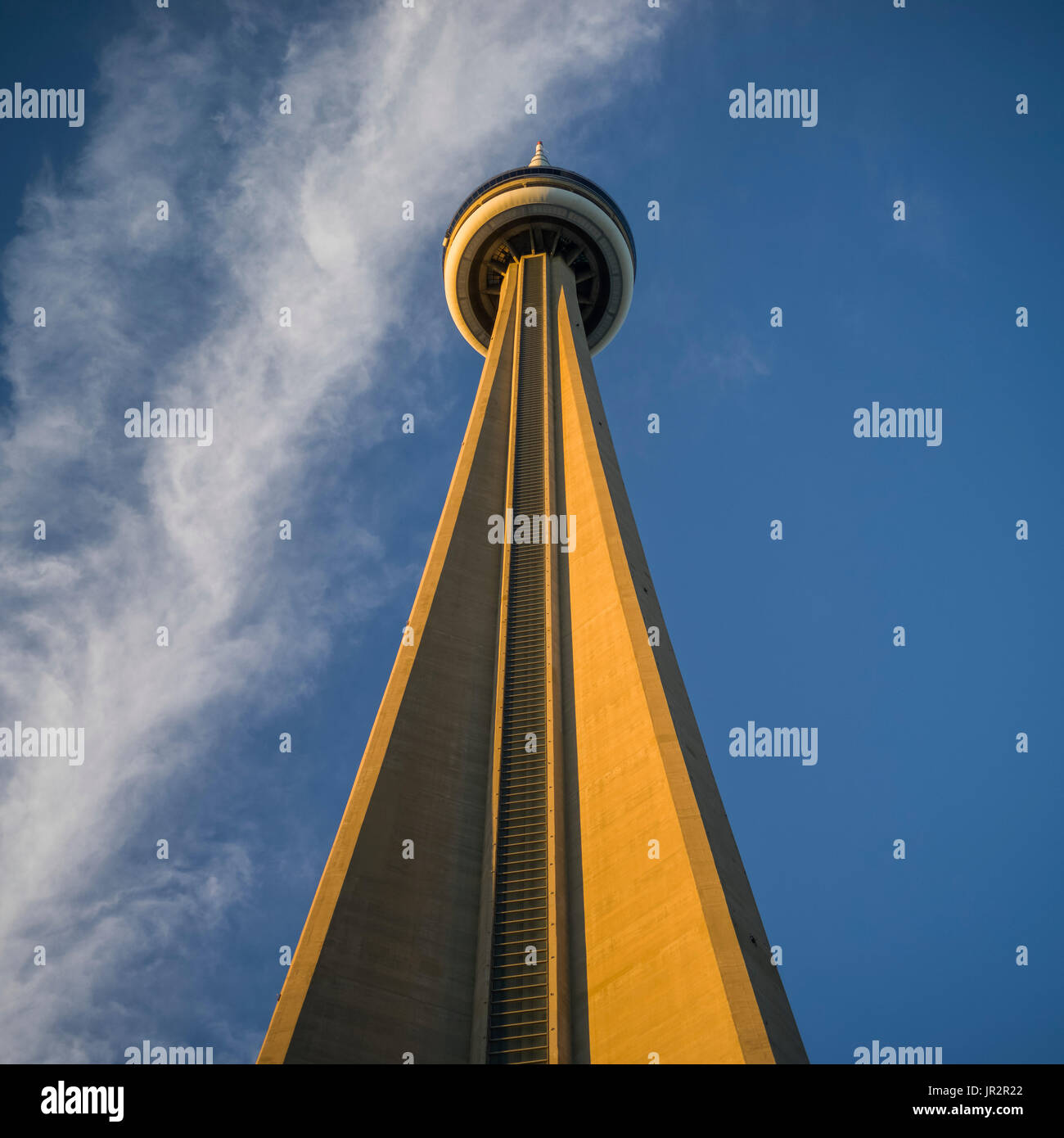 Low Angle Blick auf den CN Tower vor einem blauen Himmel mit Wolken; Toronto, Ontario, Kanada Stockfoto