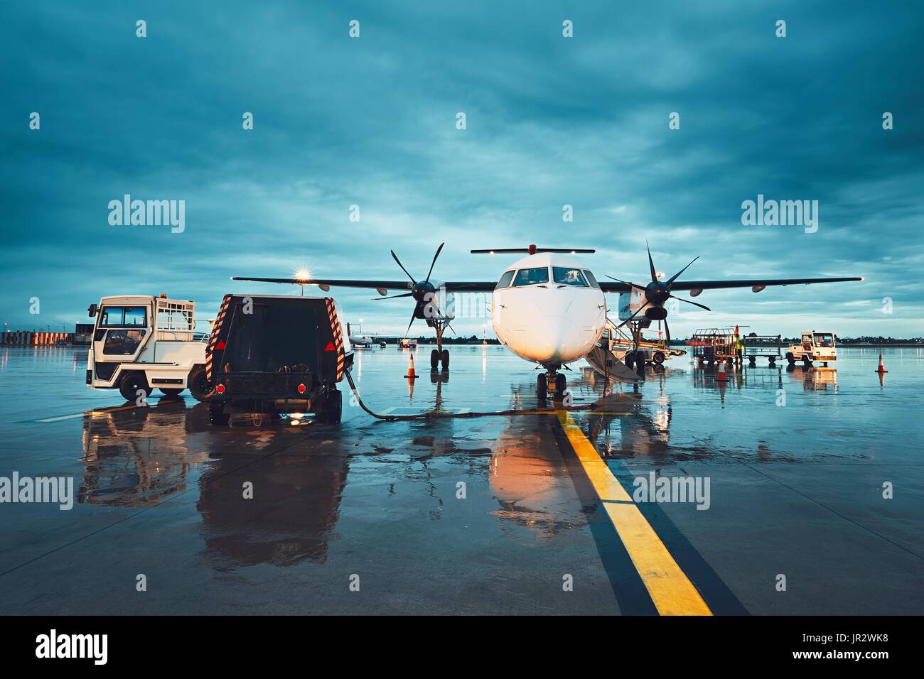Ein geschäftiger Flughafen im Regen. Vorbereitung der Propellerflugzeug vor dem Flug. Stockfoto