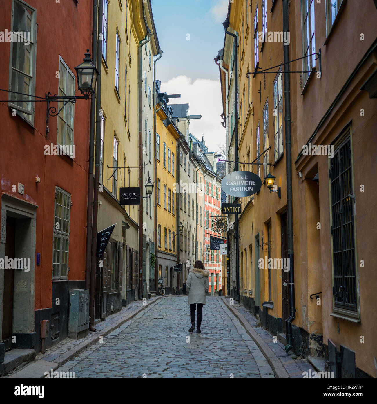 Eine Frau auf der Straße zwischen bunten Retail- und Wohnbauten; Stockholm, Schweden Stockfoto