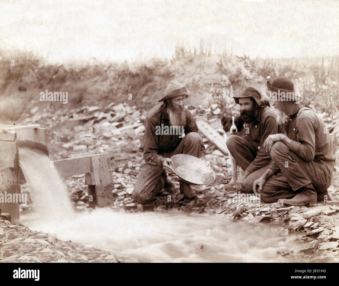 Waschen und panning Gold, Rockerville, Dakota. Old-Timer, Spriggs, Lamm und Dillon am Arbeitsplatz. Die Black Hills Gold Rush begann im Jahre 1874. Die ersten Ankömmlinge waren eine Kraft von 1000 Männern unter der Leitung von George Armstrong Custer, berichtet, dass der Bereich Gold enthaltenen, zu untersuchen, obwohl das Land von den Sioux gehörte. Sie fanden kleine Mengen von Gold im heutigen Custer, South Dakota, und sah für bessere Standorte zu bezahlen. Sie zogen nach Norden, zur Gründung der Städte Hill City, Sheridan und Pactola. An jeder Stelle fanden sie Flocken von Gold, aber nicht die Bonanza, die sie suchten. Wenn die Dinge verändert die Stockfoto