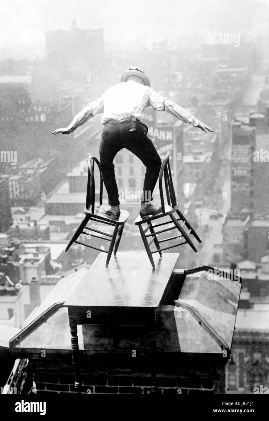 "Menschliche Fliege" Reynolds auf einem Dach in New York City. John "Jammie" Reynolds (geboren 1890 oder 91 -?) war ein US-amerikanischer Draufgänger. Wenig ist bekannt über das frühe Leben, was aus ihm geworden, nachdem er durchführen oder sogar sein richtiger Name gestoppt. Ein Acrobat und Jongleur, wurde er unter vielen Namen - Daredevil Johnny, Draufgänger Jack das Klettern Weltwunder, die Eidechse, die menschliche Spinne und menschliche fliegen bekannt. Ein Zeitungsartikel von 1922 behauptet, dass er begann im Alter von sechs in Buffalo, balancieren auf einem Bein aus einem Fahnenmast 140 Füße in der Luft. Seinen ersten großen Stunt kam im Alter von 12, wenn er auf der Seite der alten geklettert Stockfoto