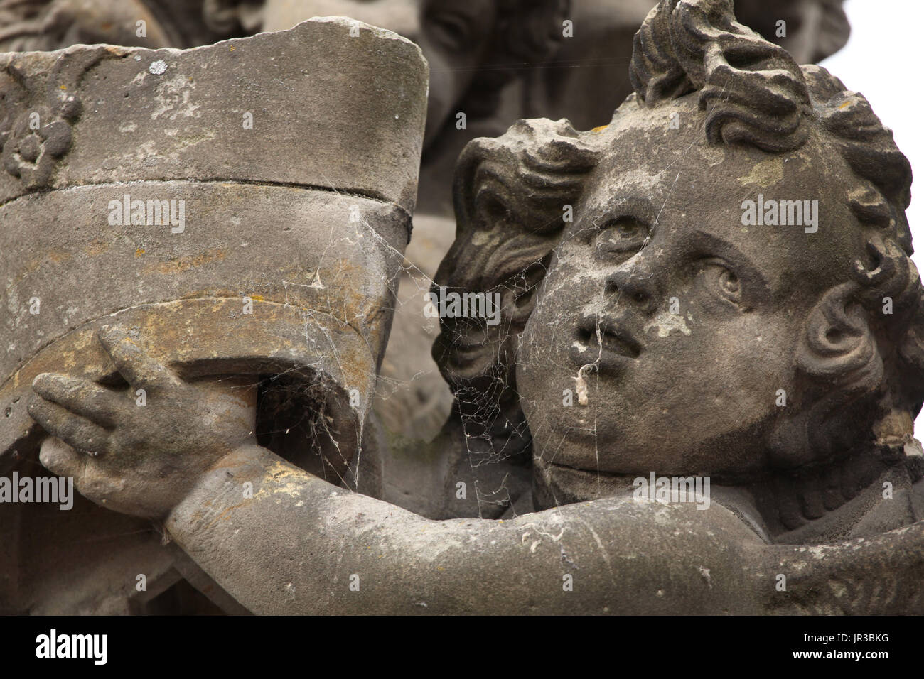 Cobweb auf der Statue ein Putto halten die gebrochenen Mitra. Detail der barocken Statuengruppe von Madonna und Saint Bernard auf der Karlsbrücke in Prag, Tschechien. Das Original aus dem Jahre 1709 geschnitzte Lausitzer-böhmischen Barock-Bildhauers Matěj Václav Jäckel wurde 1979 durch eine Kopie ersetzt. Stockfoto