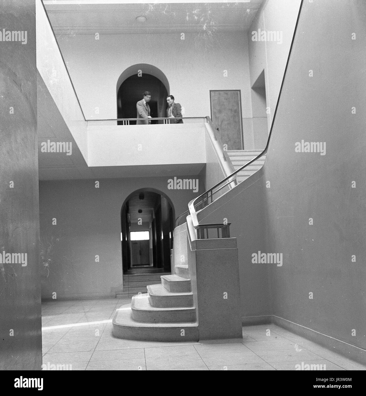 1948, historische, zwei männliche Professoren haben ein Gespräch an der Oberseite der beeindruckende Treppe in der Eingangshalle auf die Physik und Chemie labatories an der Universität Oxford, Oxford, Engand, UK. Stockfoto