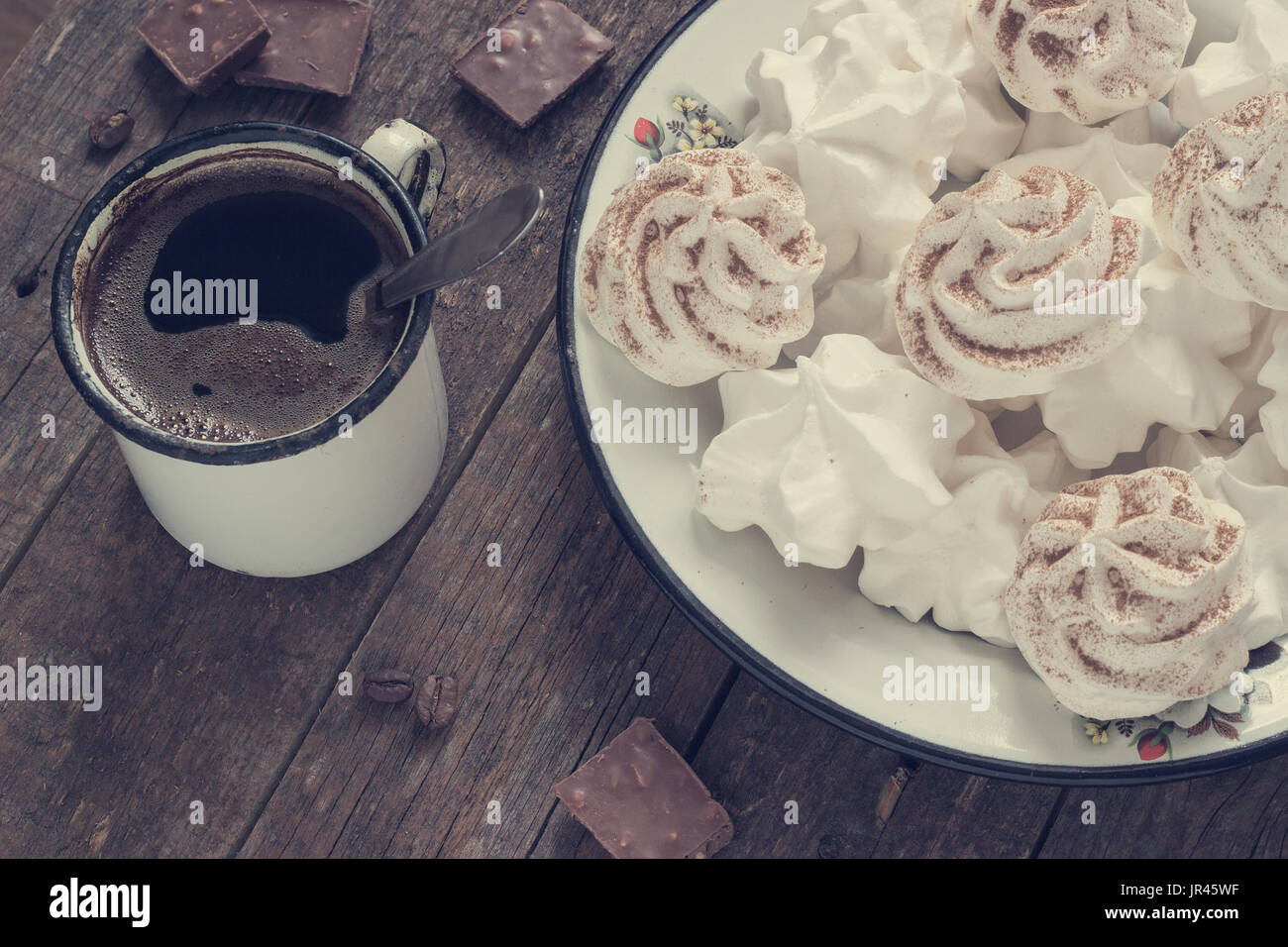weiße Baiser auf dunklem Holz Hintergrund mit Retro-Metall Kaffee Becher Muskelaufbau Stockfoto