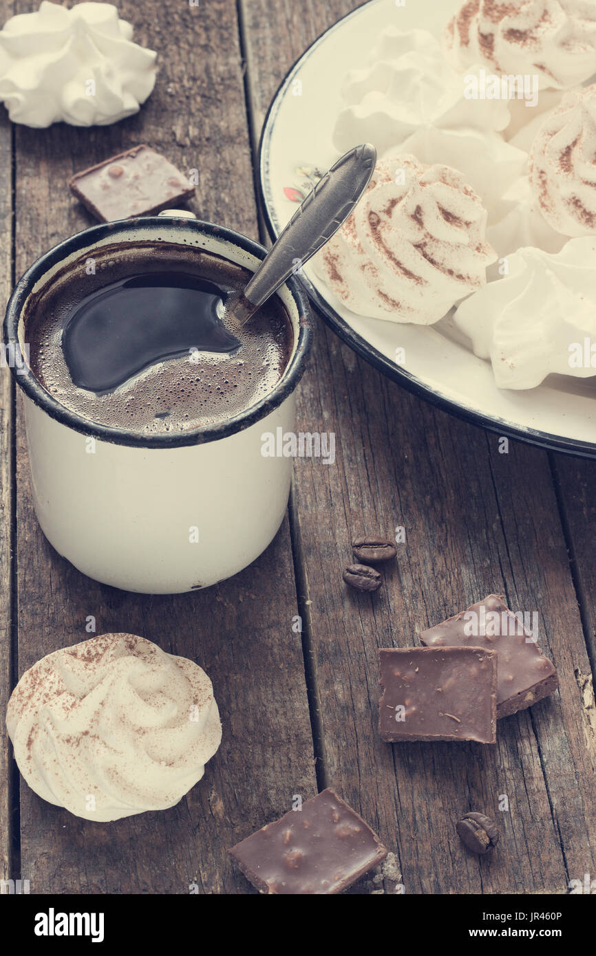 weiße Baiser auf dunklem Holz Hintergrund mit Retro-Metall Kaffee Becher Muskelaufbau Stockfoto