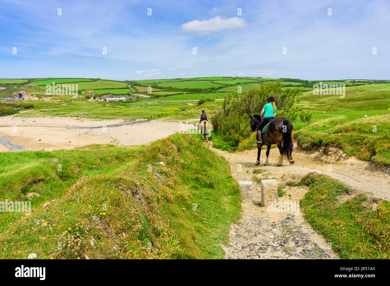 Reiten an einem britischen Strand auf dem South West Coast Path am Gunwalloe Beach, Lizard Peninsula, Cornwall im Sommer Stockfoto