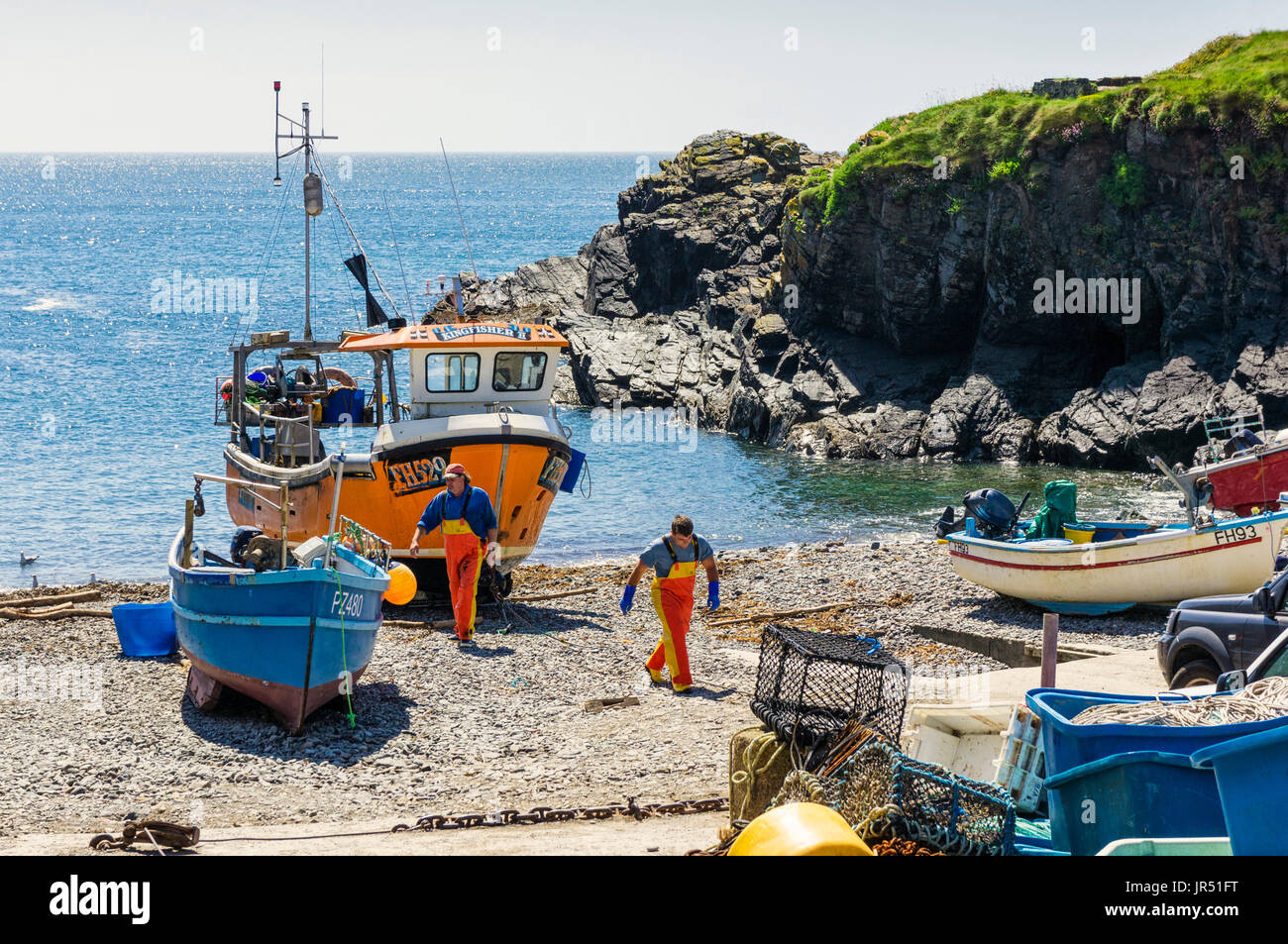 Fischerboot und Fischer bei Cadgwith Cove, Lizard Halbinsel, Cornwall, Großbritannien Stockfoto
