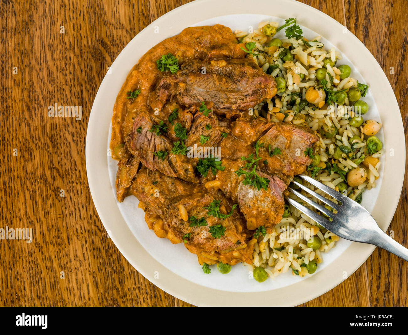Aromatisches Lammcurry mit Gemüsereis Eiche Holz dunkel Stockfoto