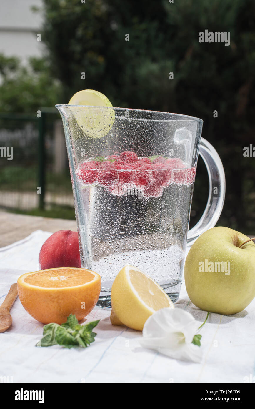 Krug und Glas Wasser mit frischen Früchten Stockfoto