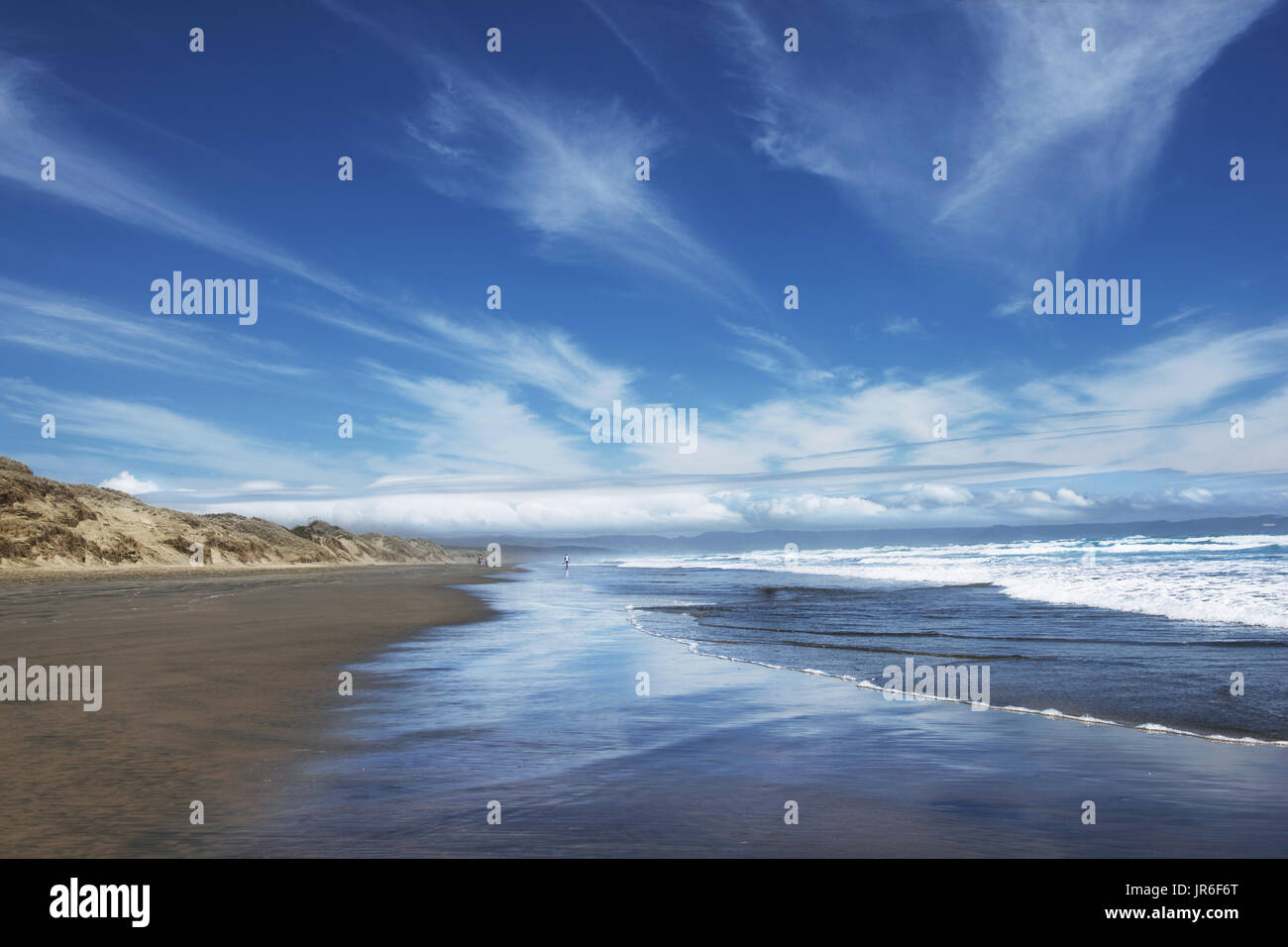 Drei Menschen, die zu Fuß entlang der Ninety Mile Beach, North Island, Neuseeland Stockfoto