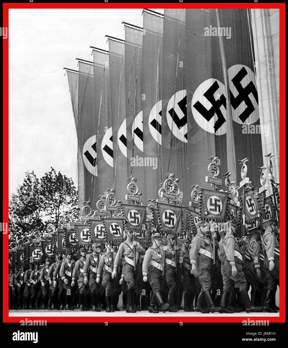 Nazi-Sturmabteilung (SA), Militärvollstrecker der Nazipartei, marschiert den Nürnberg Luitpoldhain mit großen Swastika-Bannern und regionalen Plaketten auf dem Naziparteikongress Nürnberger Rallye 1930er Jahre hinunter. Nürnberger Nazideutschland Stockfoto