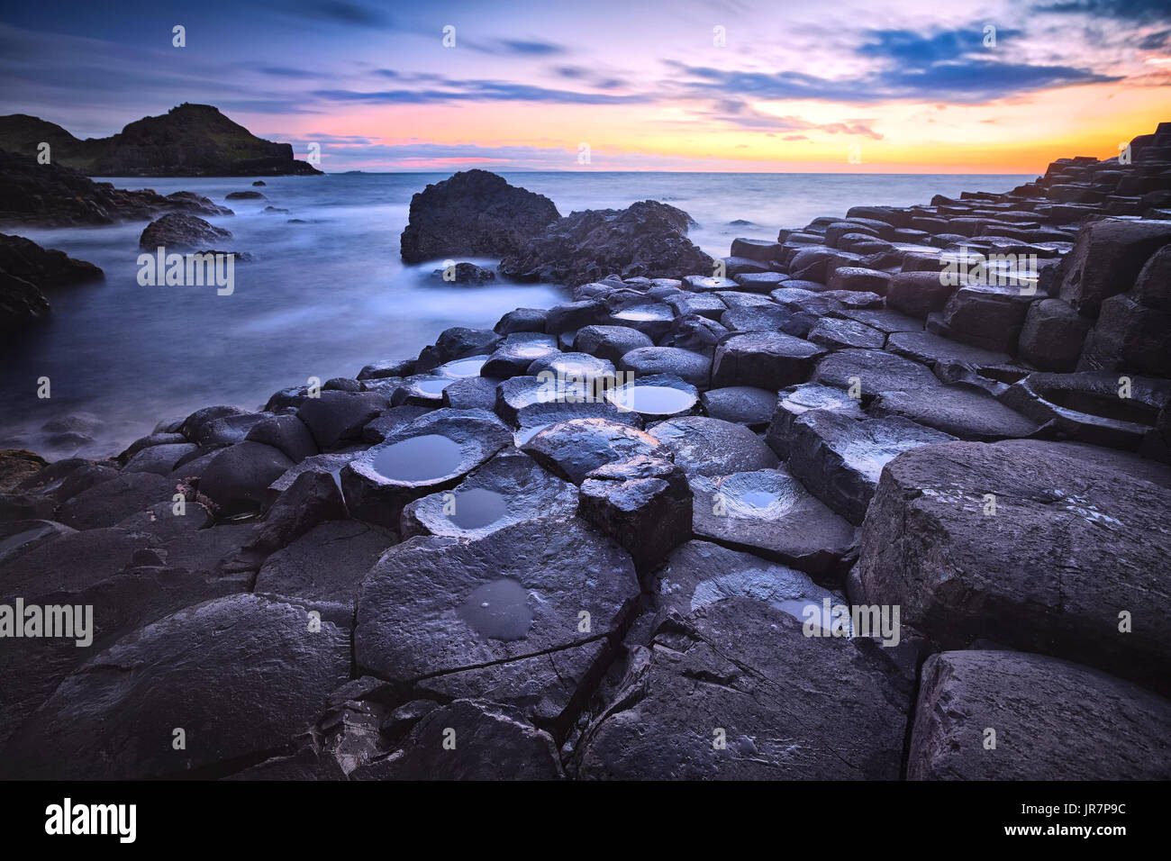 Sonnenuntergang über Basalt Felsen Bildung Giant es Causeway, Port Ganny Bay und große Stookan, County Antrim, Nordirland, Vereinigtes Königreich Stockfoto