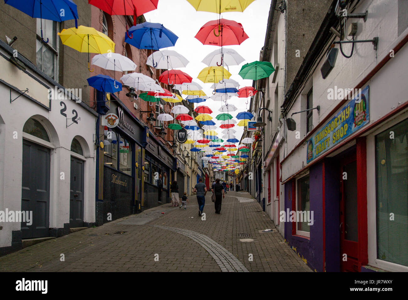 Menschen zu Fuß durch die Straße in Enniscorthy, Irland mit schwebenden Sonnenschirme für den Rockin' Food Festival eingerichtet Stockfoto