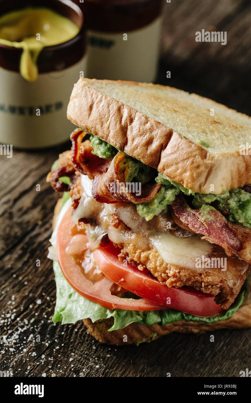 Huhn und Avocado BLT Sandwich auf rustikale Oberfläche Stockfoto