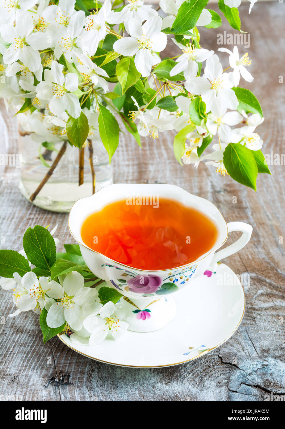 Tasse Tee und Apfelblüte im Glas auf der rustikalen Hintergrund Stockfoto