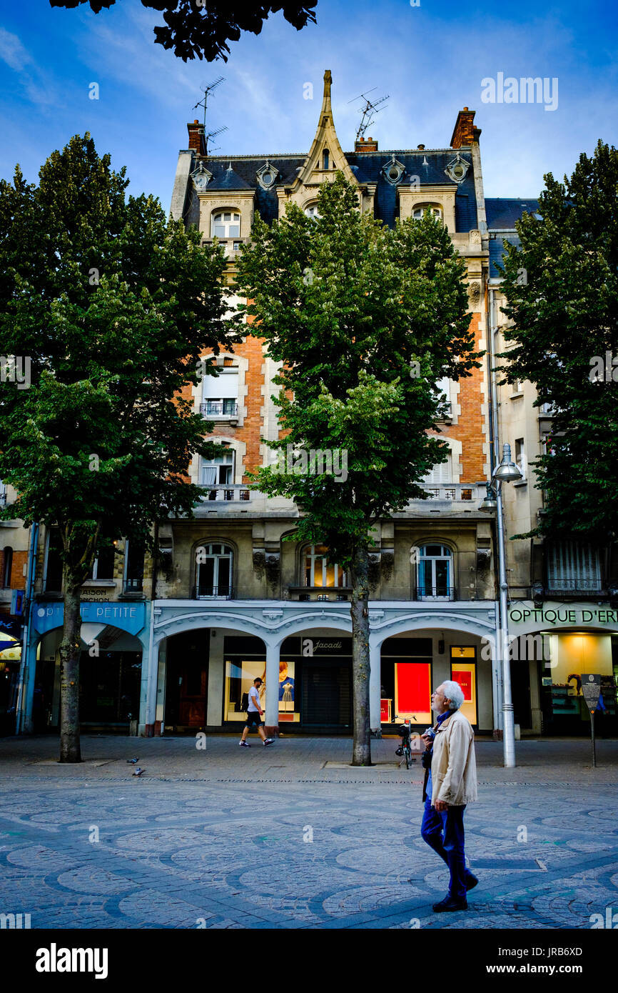 Ein Mann zu Fuß in den Place Drouet d'Erlon, Reims, Frankreich am Abend Stockfoto