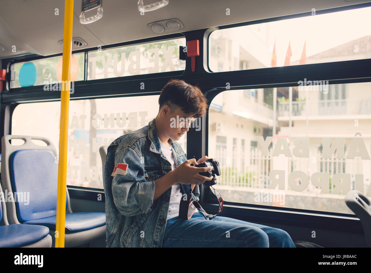 Asiatischen männlichen Touristen fotografieren der Stadt aus dem Fenster des Busses Stockfoto