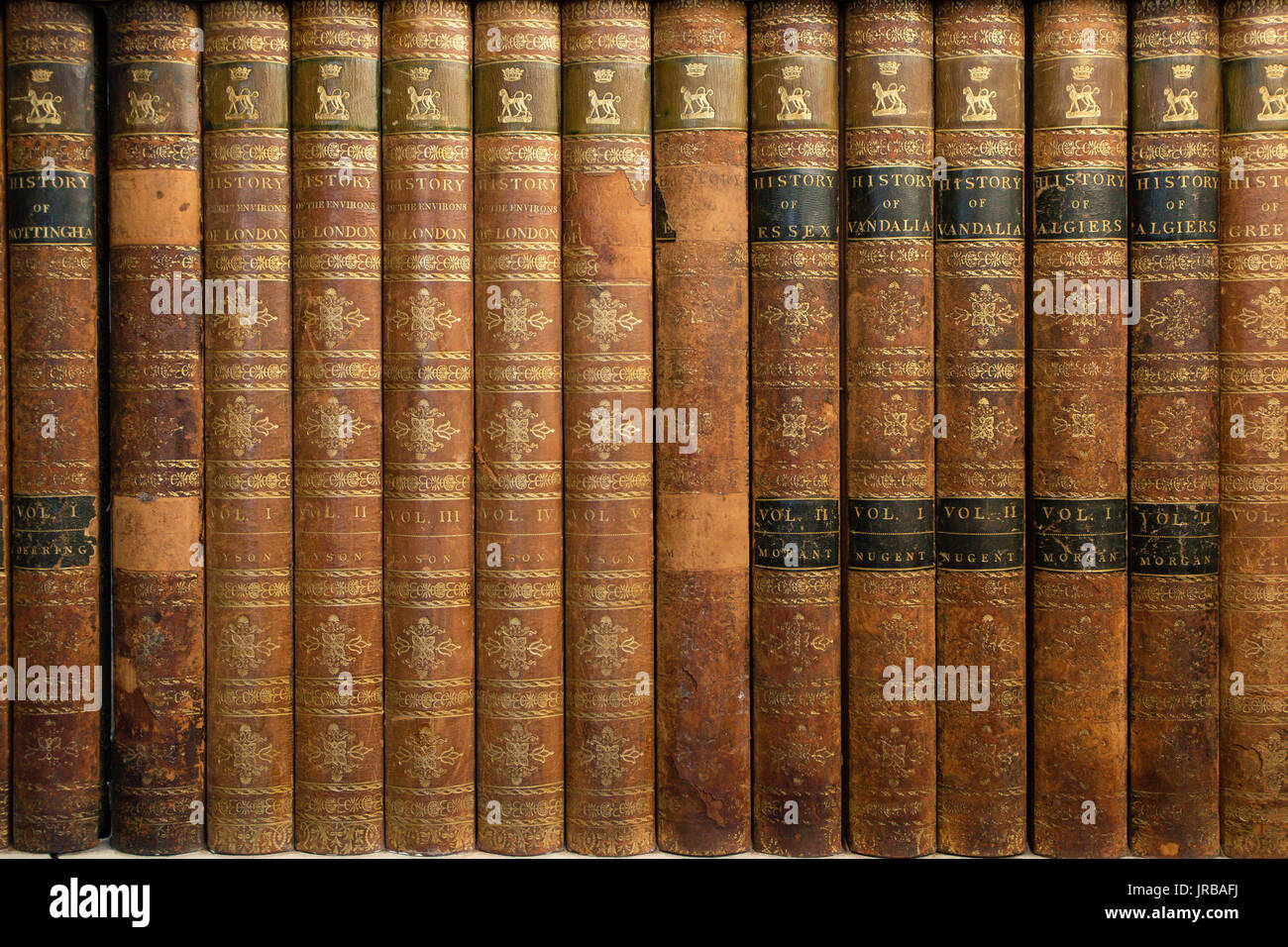 Sammlung von alten antiken Büchern in einem braunen Deckel auf dem Bücherregal Stockfoto