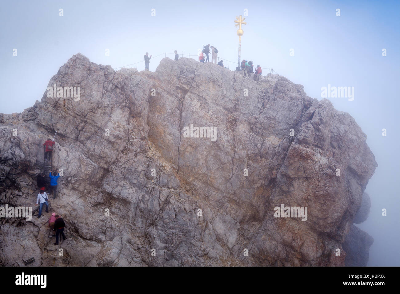 Menschen auf der Zugspitze Gipfel mit Gipfelkreuz, Bayern, Deutschland Stockfoto