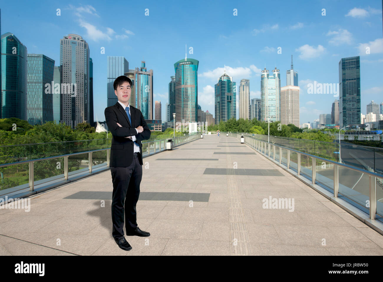 Asiatische Geschäftsmann, der mit seinen Armen mit Shanghai Lujiazui Finanz- und Geschäftsviertel Trade Zone Wolkenkratzer in Shanghai China gekreuzt Stockfoto