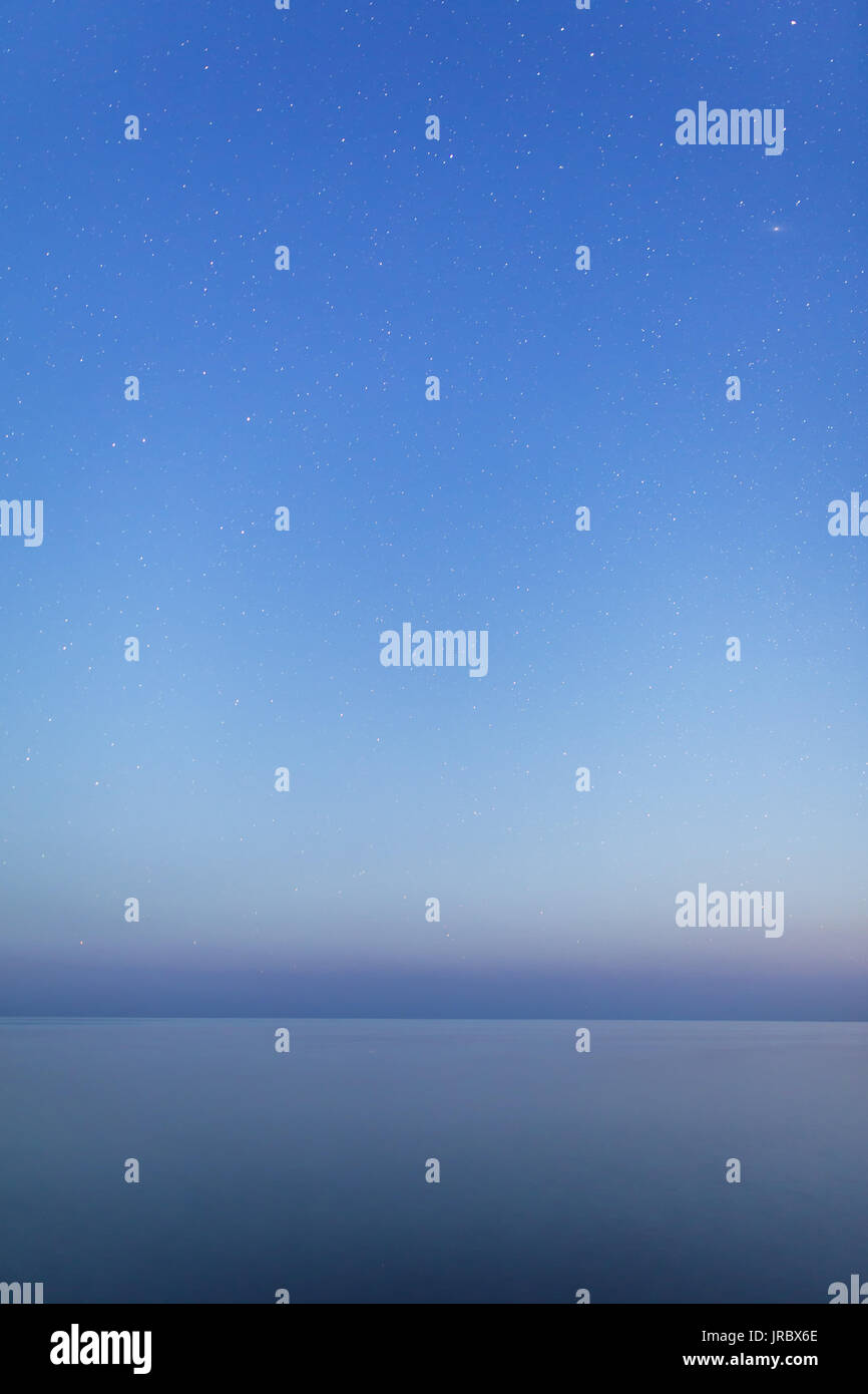 Zusammenfassung Hintergrund. Sternenhimmel über ruhige See Stockfoto