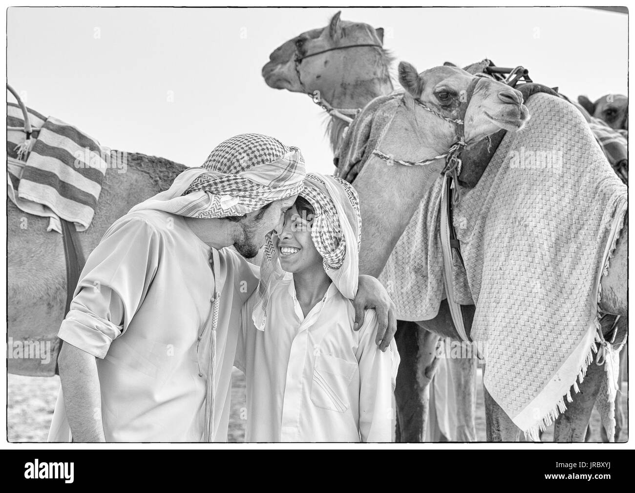 Rub al Khali Wüste, Abu Dhabi, Vereinigte Arabische Emirate, 22.Juli 2017: Männer Gruß an ein Kamel in der Wüste Stockfoto