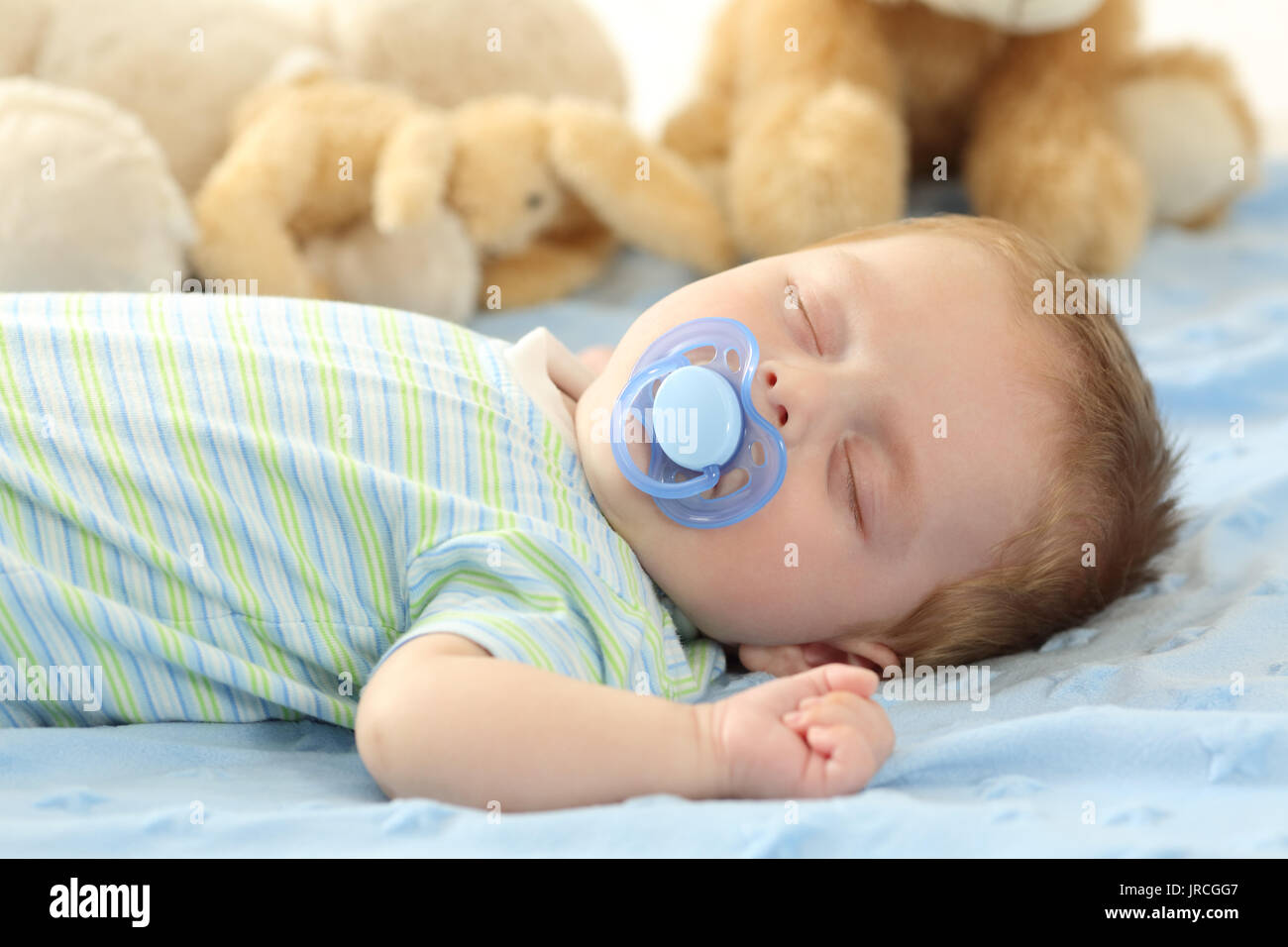 Cute Baby schläft mit einem Schnuller auf einem Bett. Stockfoto