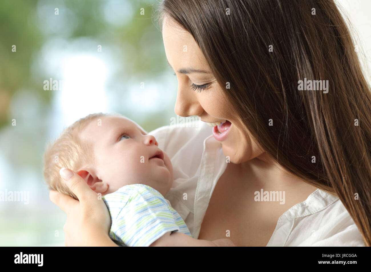 Stolze Mutter hält ihr Baby und suchen einander Stockfoto
