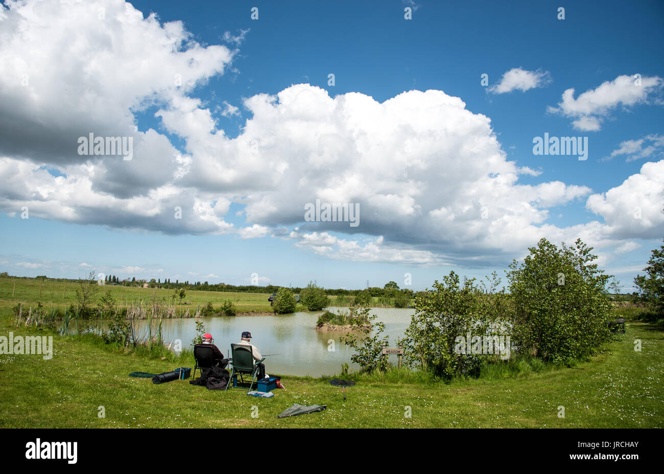 Kent, Großbritannien - 14 Mai 2017: Reifen erwachsenen Männer angeln an einem schönen See in der Nähe von Sandwich in Kent District, Vereinigtes Königreich. Stockfoto