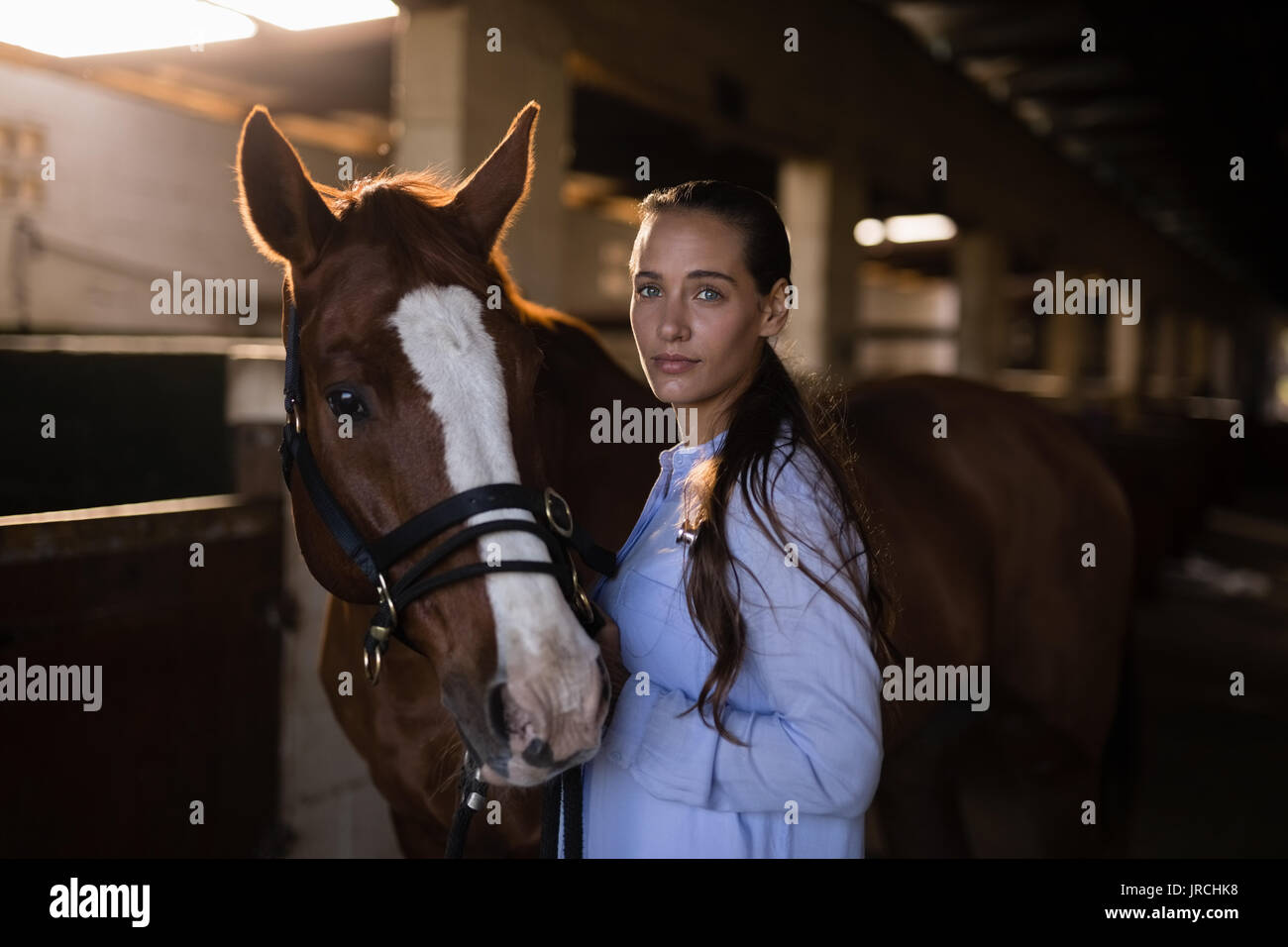 Portrait von zuversichtlich weiblichen Tierarzt Pferd im Stall stehen, Stockfoto