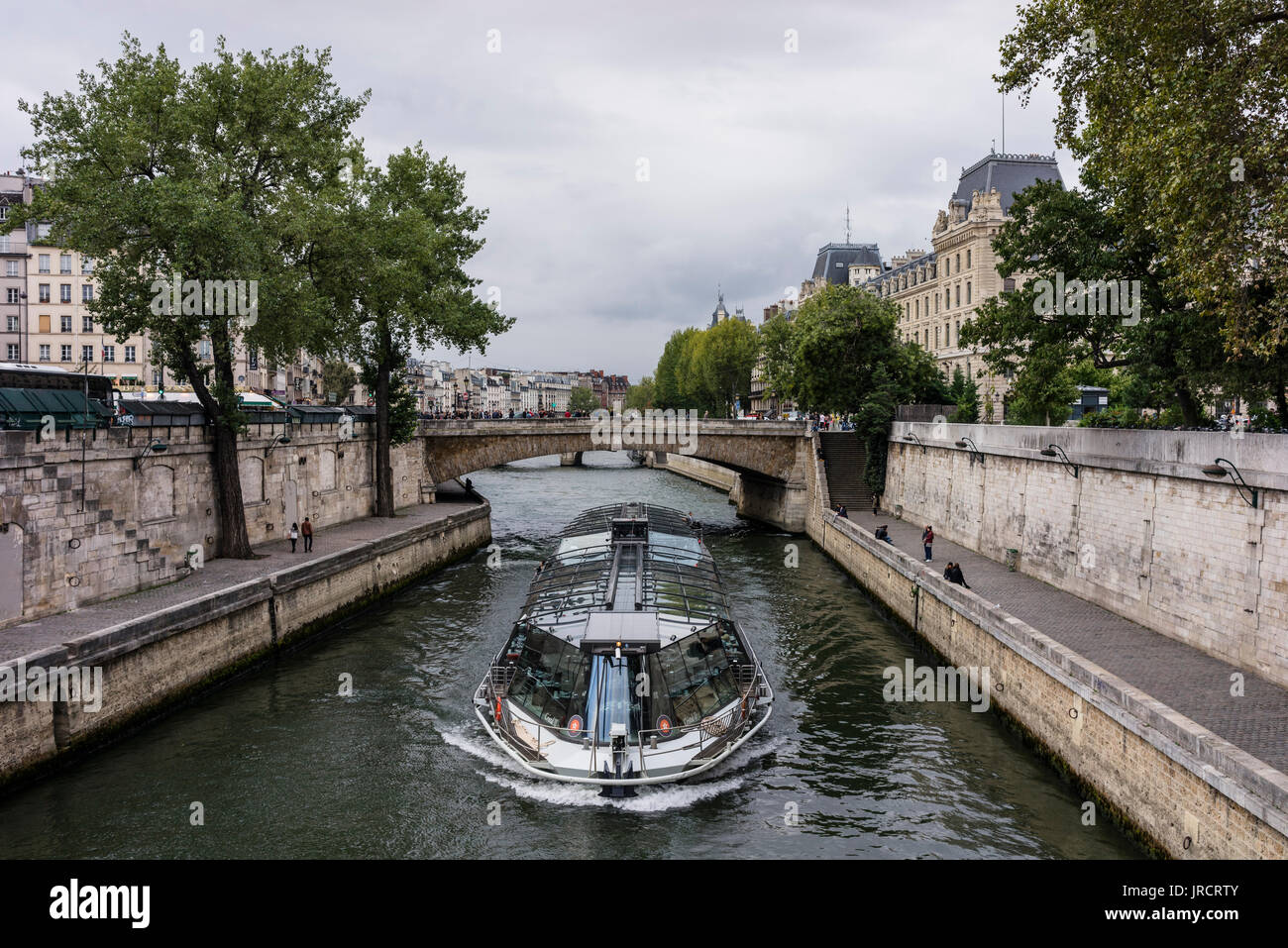 Bateau Mouche touristenboot vorbei am Petit Pont Quai de Montebello. Stockfoto