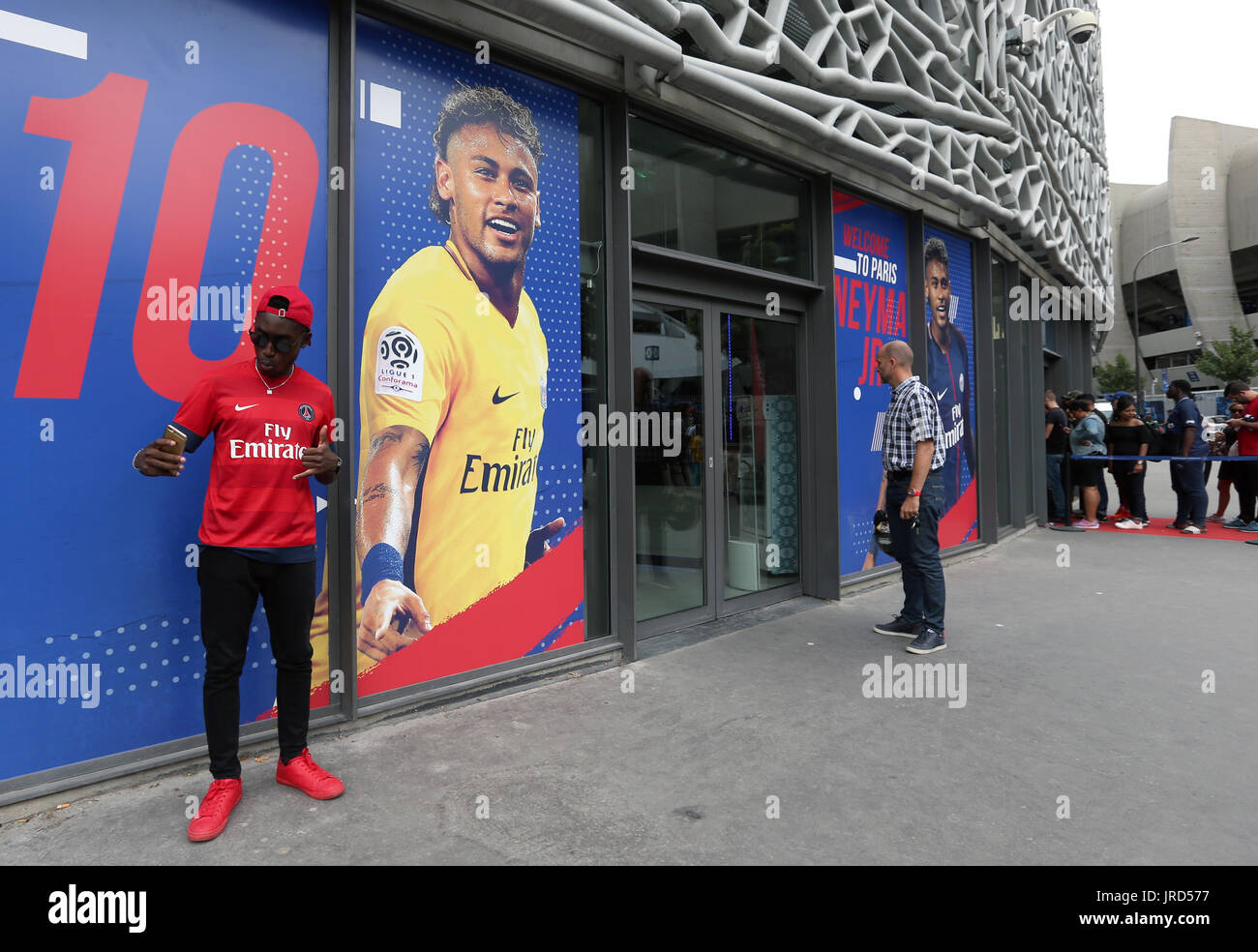 Paris Saint-Germain Fan posiert für ein Foto neben einem Poster von Neymar außerhalb der Club-Megastore als Fans Schlange am Parc des Princes, Paris Saint-Germain seine Welt Rekord £ 200 Millionen-Transfer vom FC Barcelona nach. Stockfoto