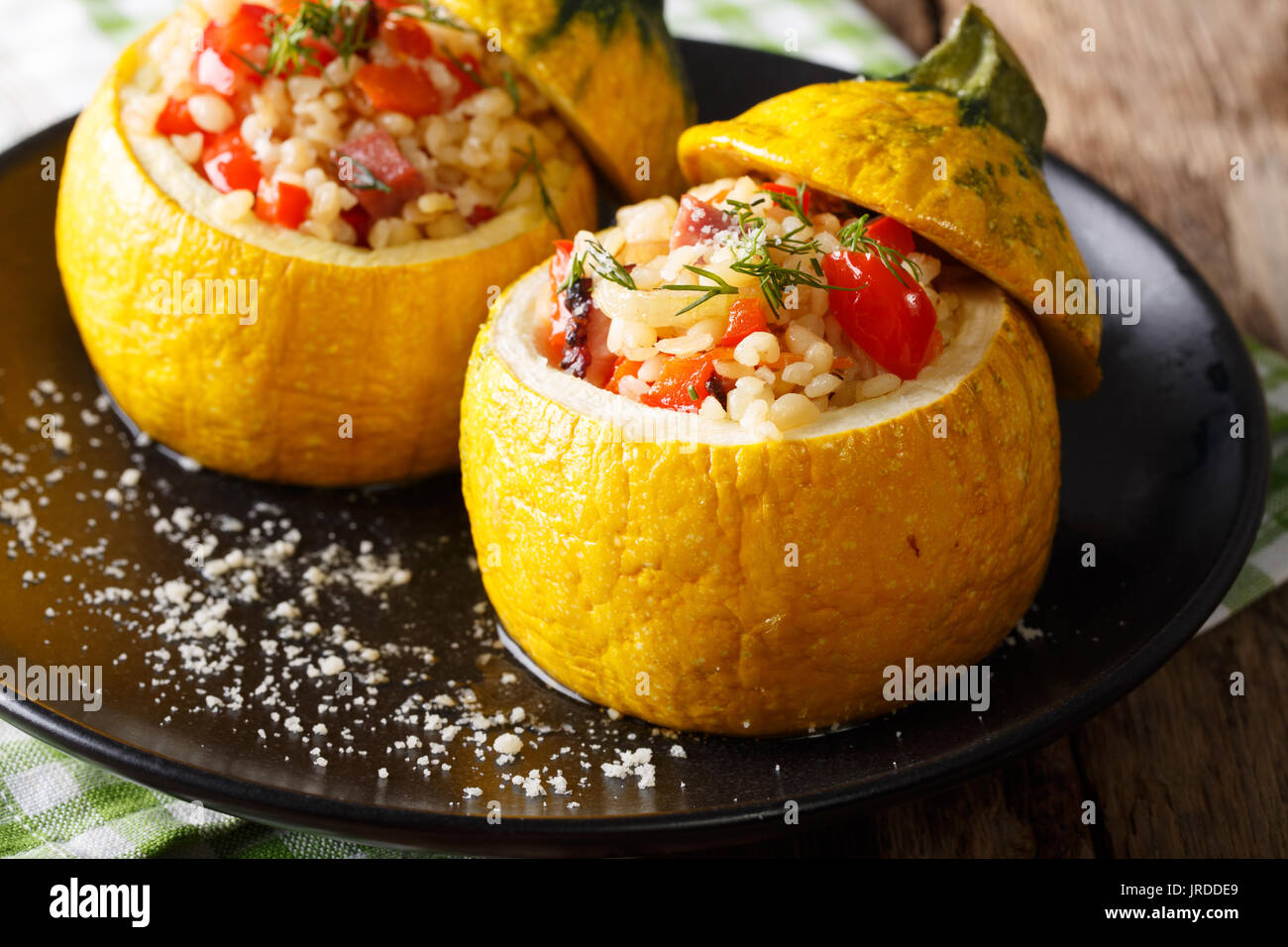 Gelbe Zucchini gefüllt mit Bulgur, Fleisch und Gemüse close-up auf einem Teller. Horizontale Stockfoto