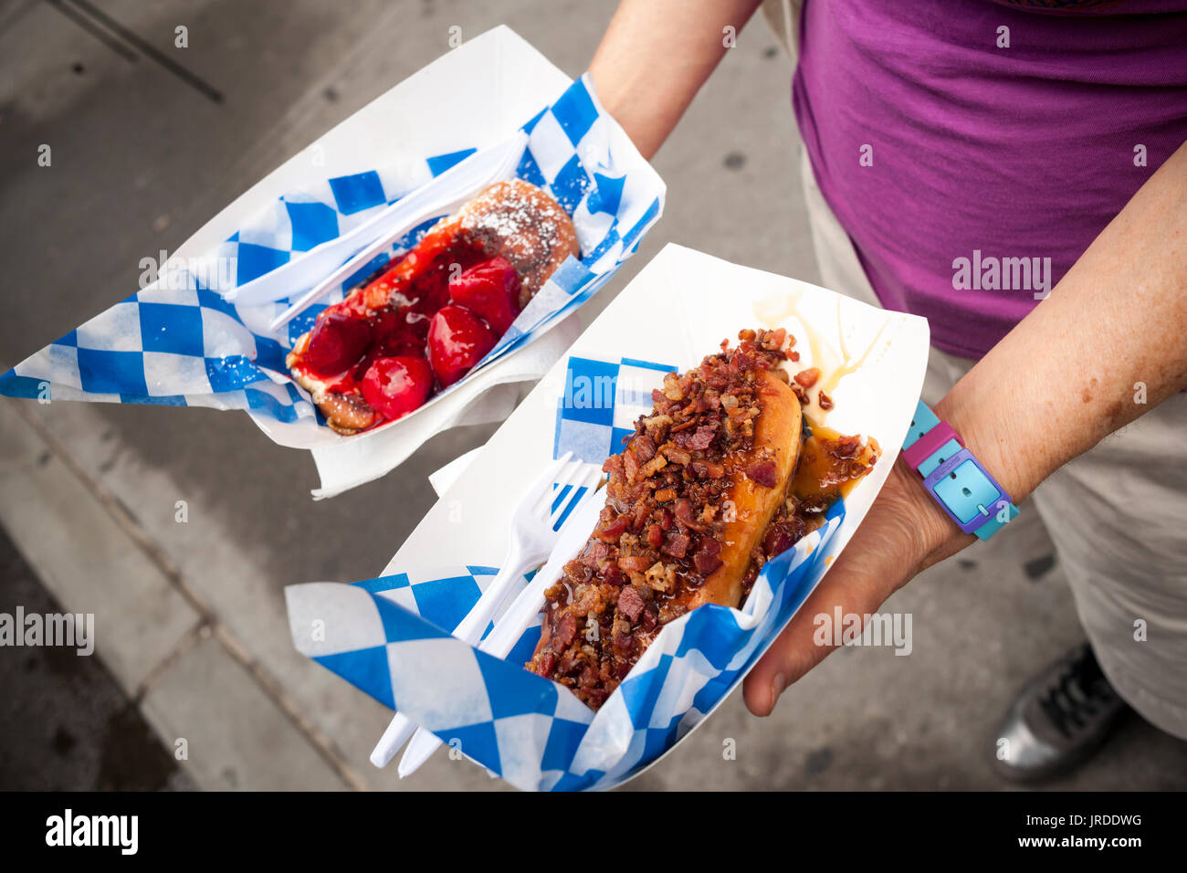 Hungrige Feinschmecker Line-up an ein IHOP gebrandmarkt Imbisswagen in der Flatiron Nachbarschaft von New York für kostenlose Proben von ihren neuesten Angebot, frittierte Krapfen in Vanille French Toast Teig getaucht und mit herzhaften und süßen Belag fertig. Die International House of Pancakes-Produkte haben entweder eine Ahorn-Speck-Glasur oder eine Erdbeere und eine Creme. Eine dritte Sorte Apfel Krapfen ist nur in ihren Restaurants verfügbar. iHOP ist eine Marke der DineEquity die auch Applebees besitzt. Sie steuern über 3700 Restaurants in die kombinierte Ketten, 99, die Prozent davon Franchise sind. (© Richard B. Levine) Stockfoto