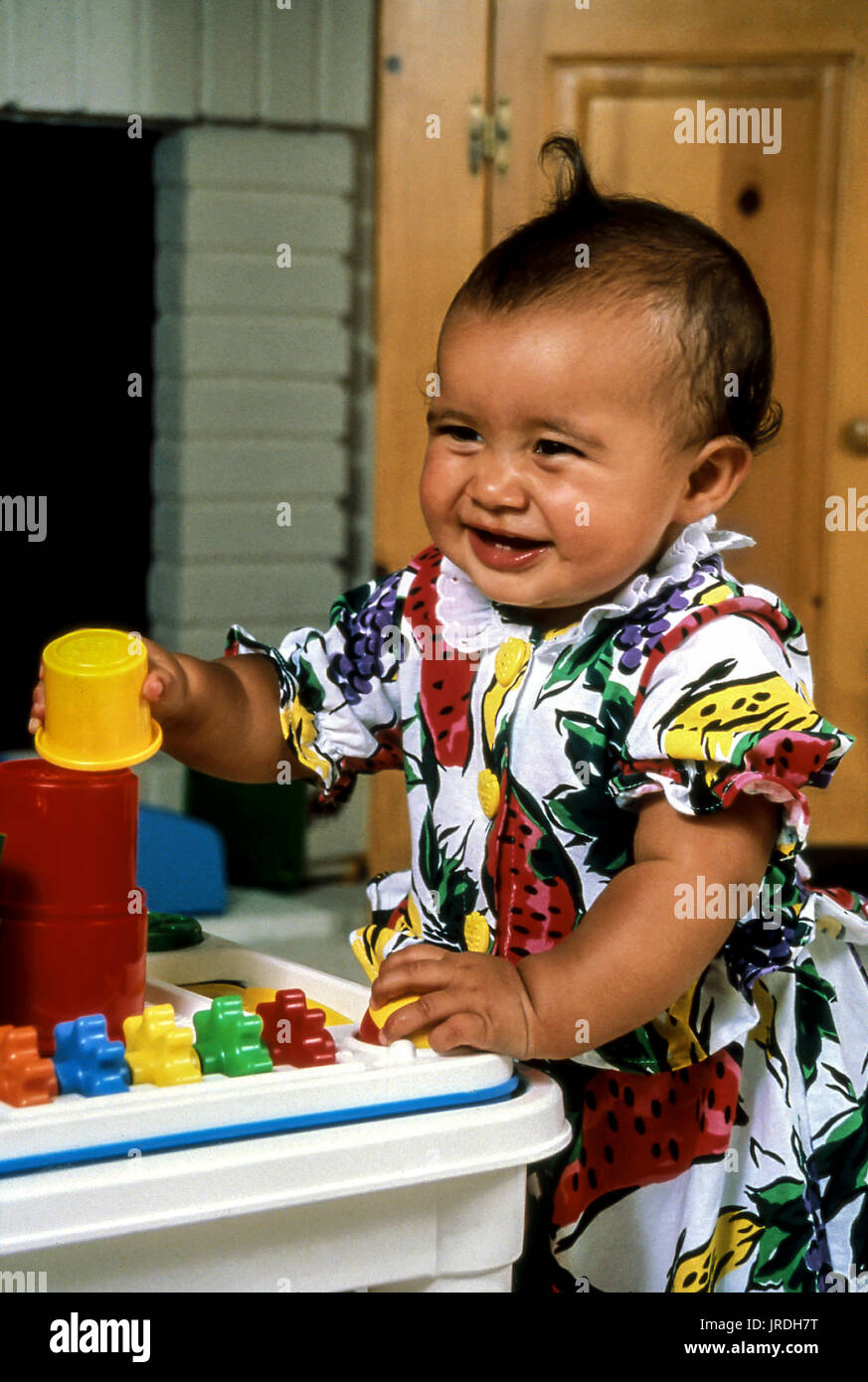 18 Monate alten ethnischen Baby Mädchen spielen mit farbigen stapeln Spielzeug Kinder Spaß POV © Myrleen Pearson Stockfoto