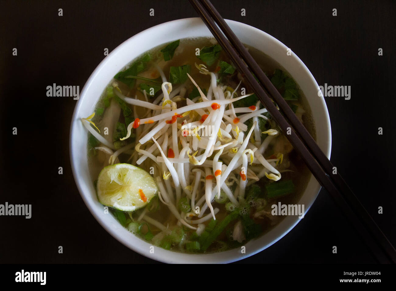 Eine Schüssel Pho Suppe mit Kalk und Sojasprossen Stockfoto