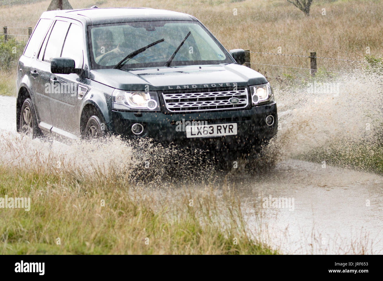 Ein Fahrer der Bekämpfung der Überschwemmungen im Sommer Regenguss in Flintshire, Wales, Großbritannien Stockfoto