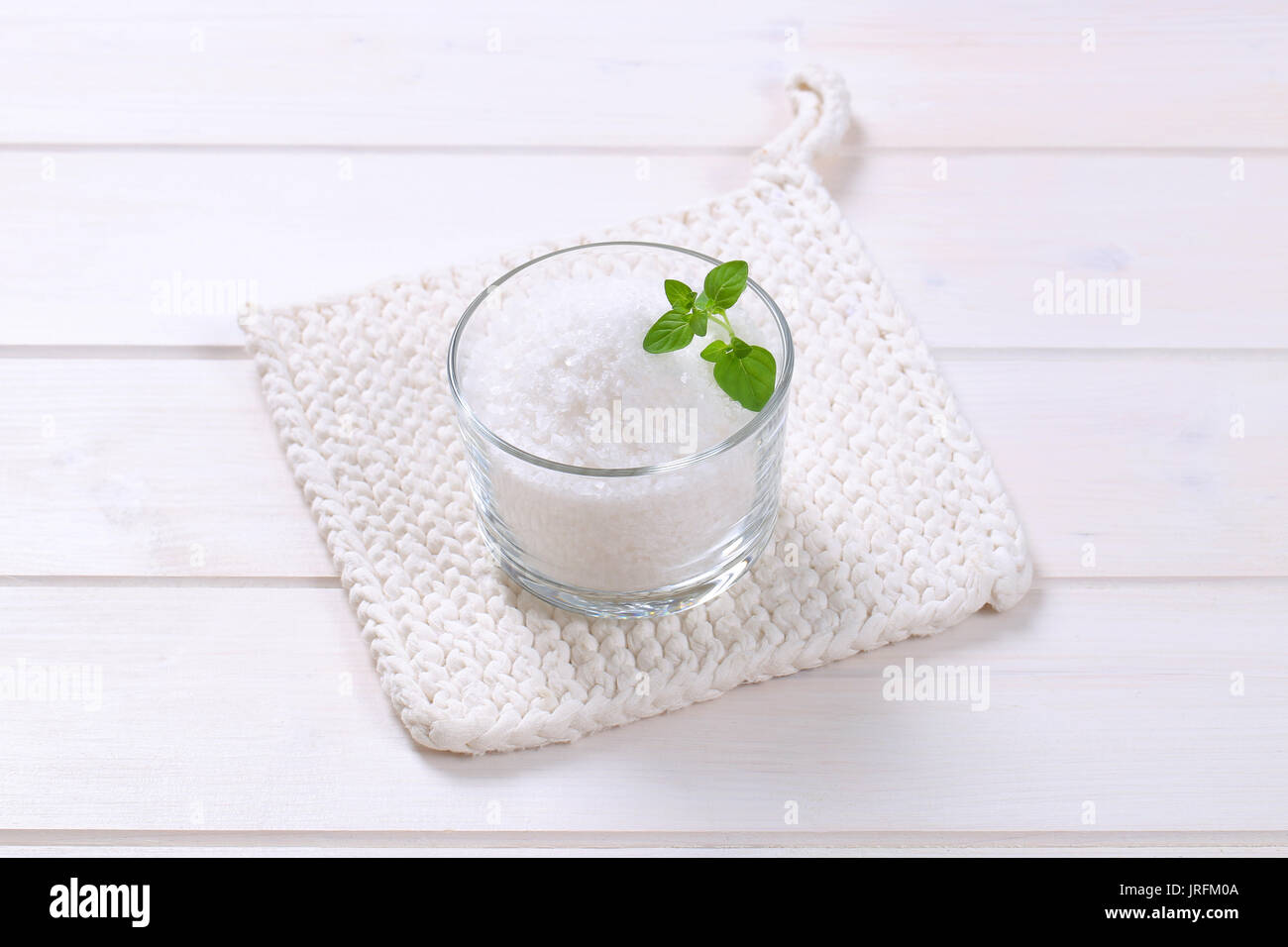 Glas grobkörniges Meersalz auf White Table mat Stockfoto