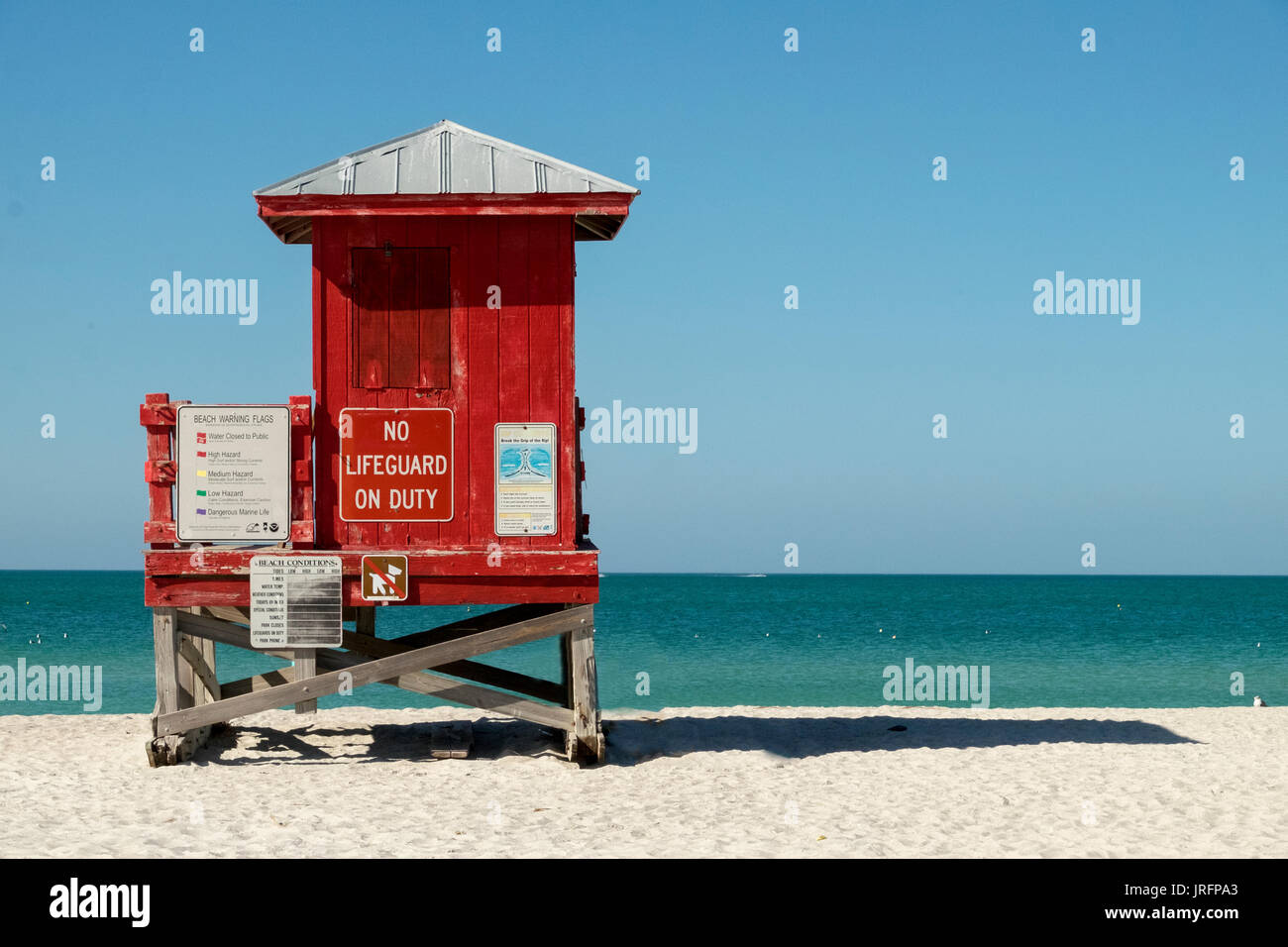 Leuchtend rote Rettungsschwimmer stehen am weißen Sandstrand von Clearwater, Florida, USA Stockfoto