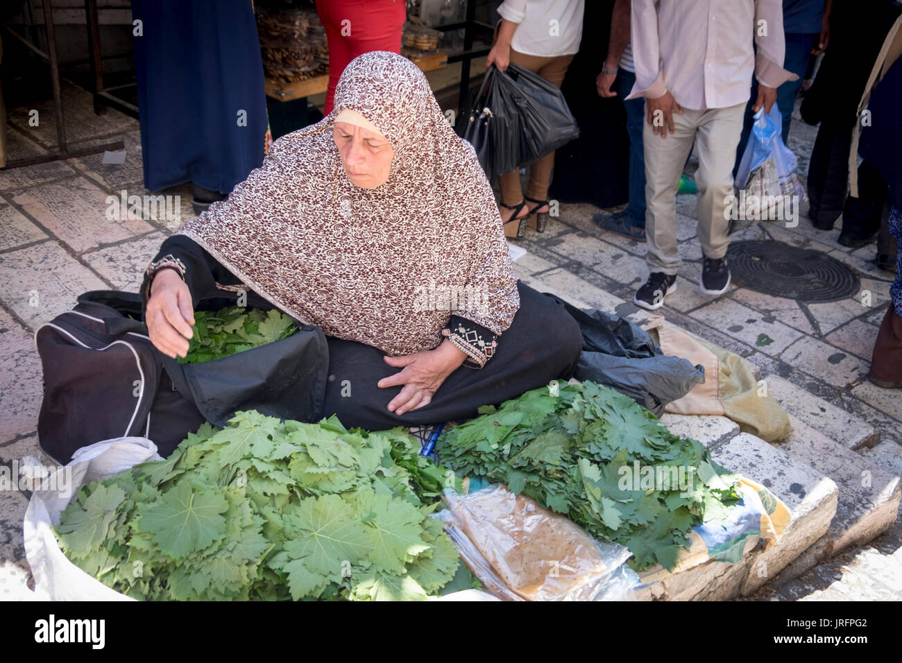 Palästinensische Frau macht ein karges Leben durch den Verkauf von frischem Gemüse auf dem Markt der arabischen Viertel der Altstadt von Jerusalem. Stockfoto