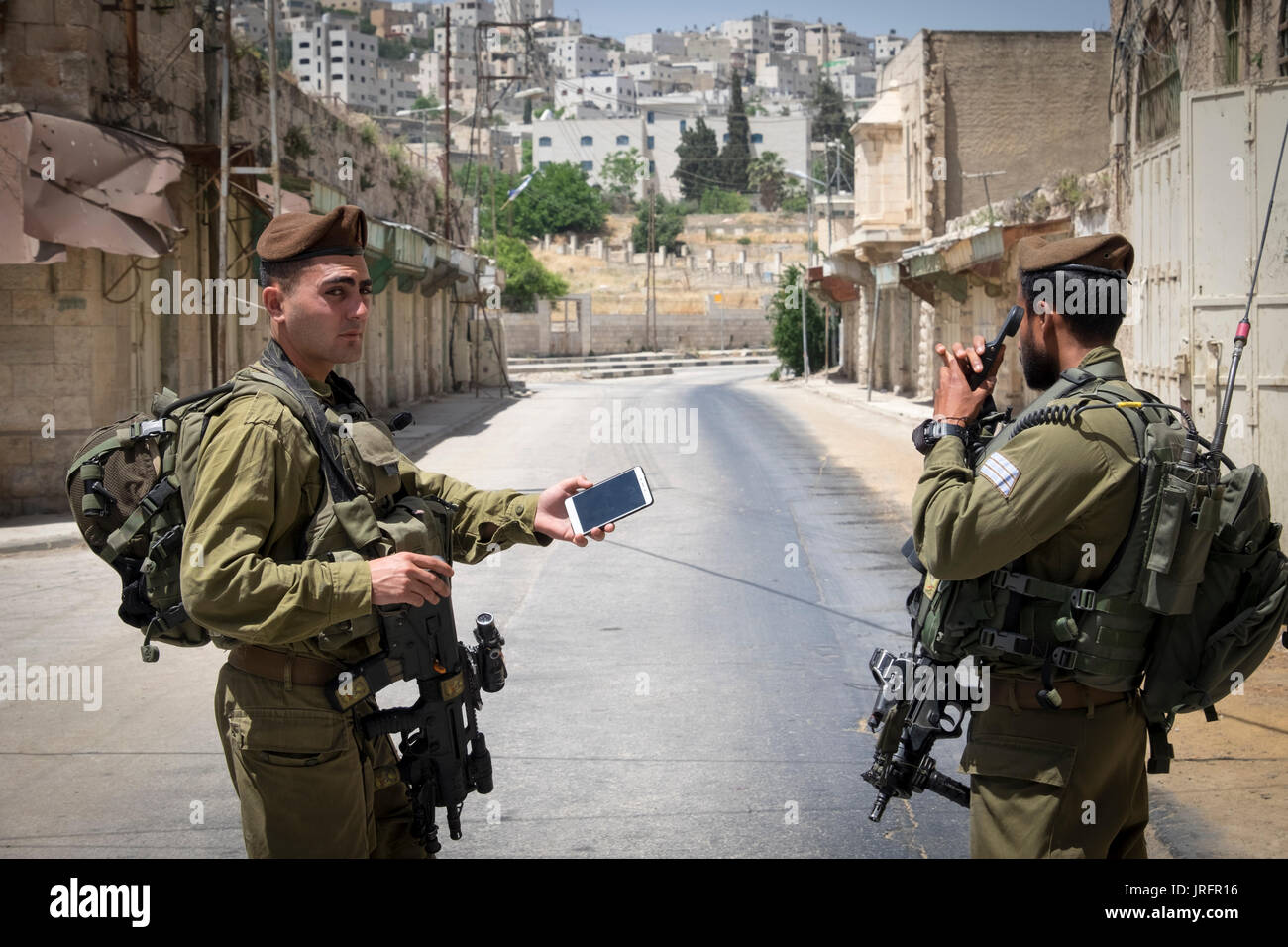 Israelischer Soldat bewacht ein ehemaliger bustiling Hebron market Street jetzt für die Palästinenser aufgrund einer landnahme von 850 israelische Siedler geschlossen in der Nähe Stockfoto