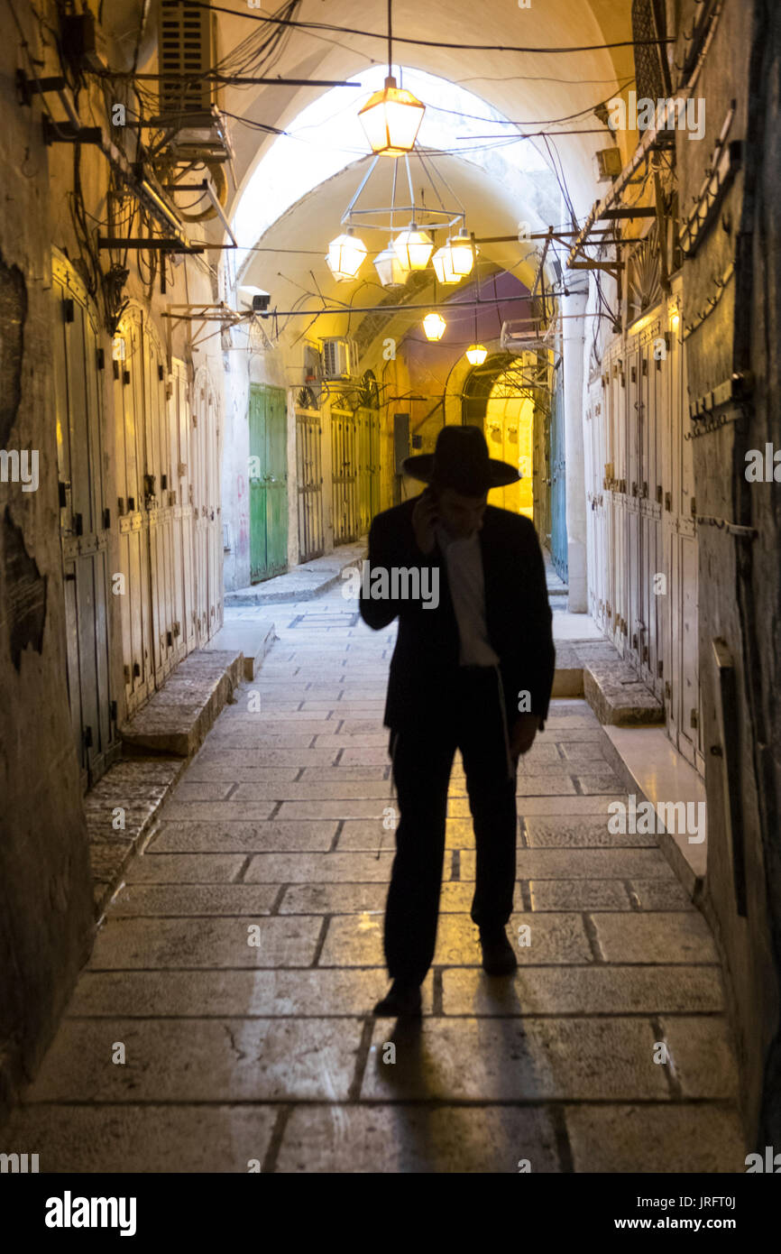 Ein orthodoxer Jude Yeshivish, Wanderungen in die menschenleeren Straßen der Altstadt von Jerusalem durch eine Mandat Schließung von den israelischen Behörden. Stockfoto