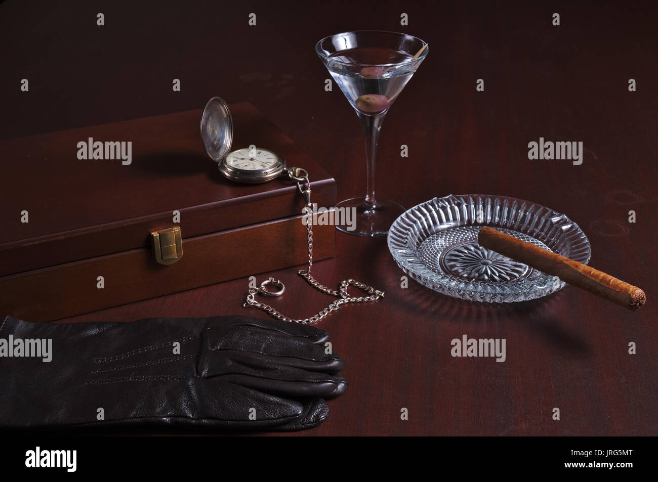 Cigarbox, Taschenuhr, Martini, kubanische Zigarre und Leder Handschuhe. vintage Herren Thema Stockfoto