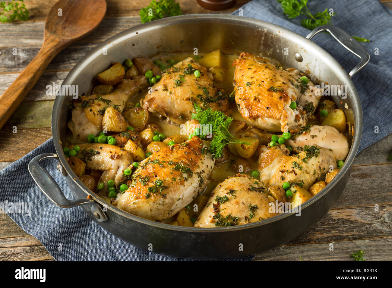 Hausgemachte gebackenes Huhn Vesuvio mit Erbsen und Kartoffeln Stockfoto