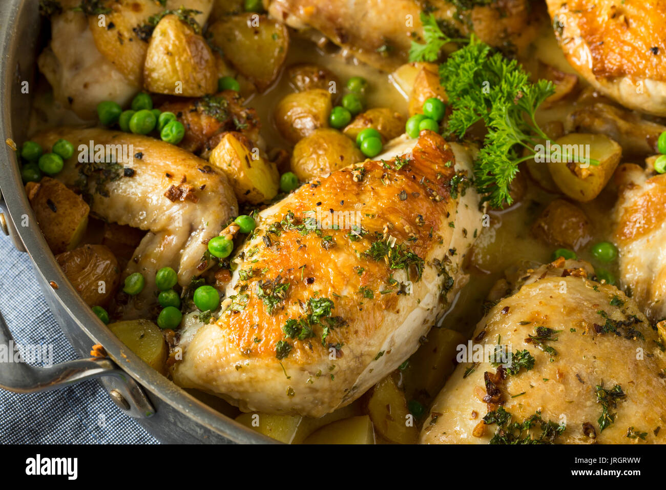 Hausgemachte gebackenes Huhn Vesuvio mit Erbsen und Kartoffeln Stockfoto