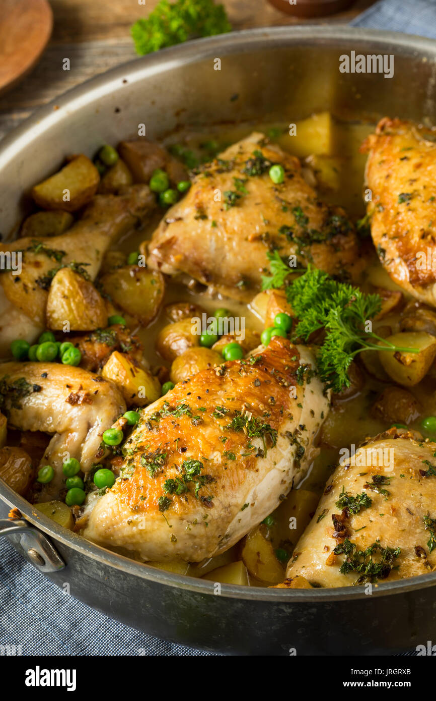 Hausgemachte gebackenes Huhn Vesuvio mit Erbsen und Kartoffeln Stockfoto