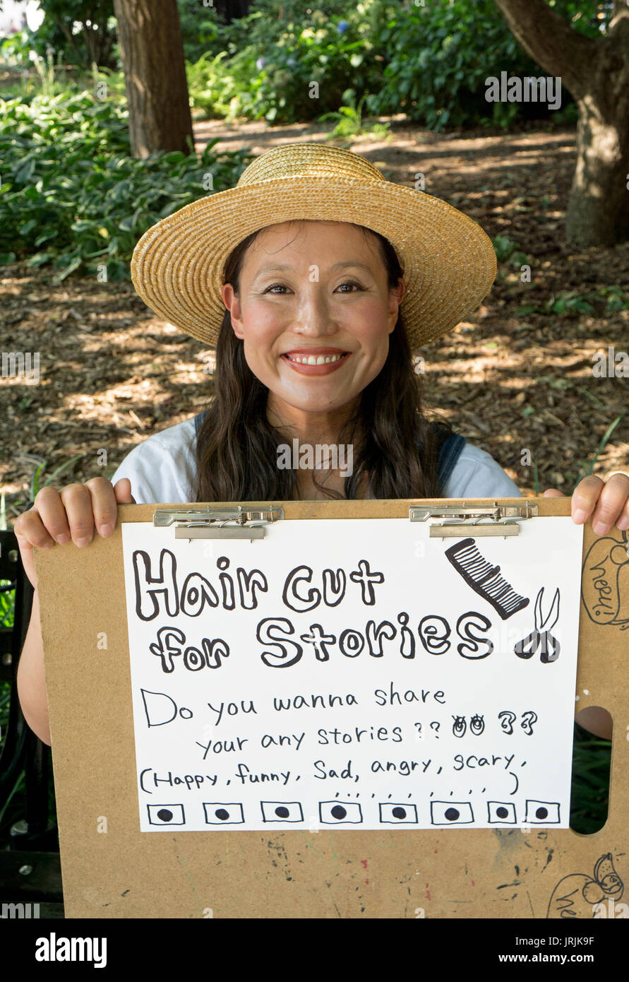 Einen attraktiven japanischen Friseur im Urlaub bietet einen kostenlosen Haarschnitt im Austausch für Geschichten. Im Washington Square Park in Greenwich Village, NEW YORK CITY. Stockfoto