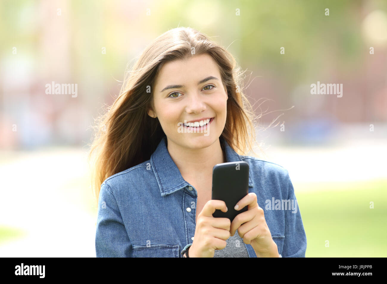 Mädchen mit einem Handy und suchen Sie allein auf der Straße Stockfoto